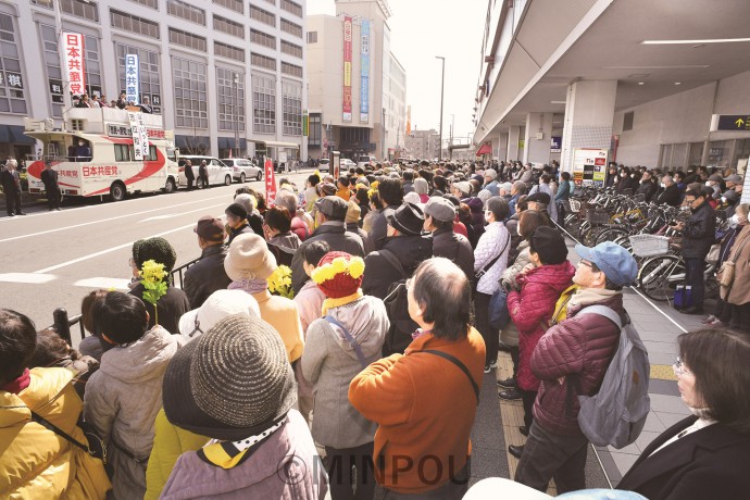 阪急曽根駅前で志位委員長の演説を聞く人たち＝２月24日、豊中市内